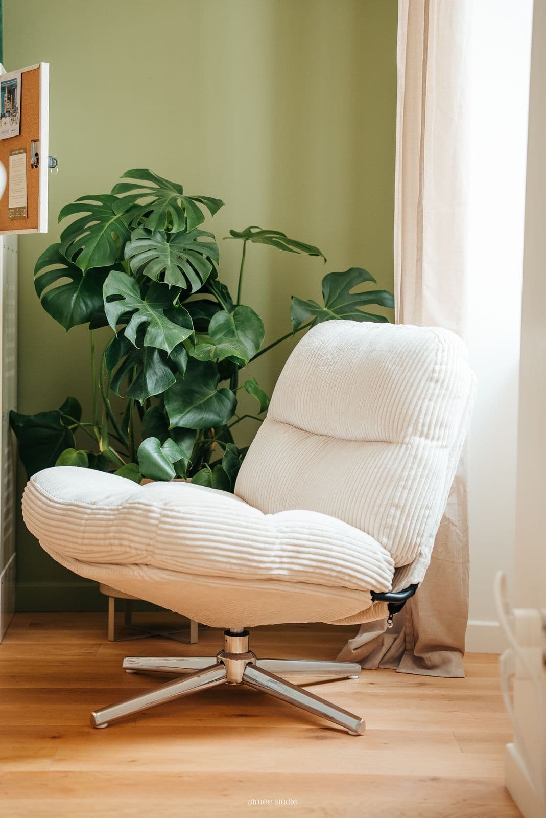Le coin lecture : un fauteuil blanc à côté d'une grande plante